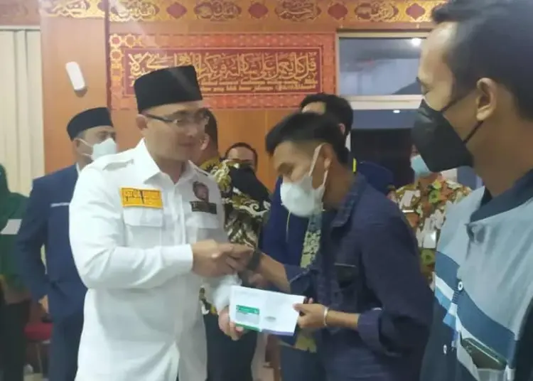 Ketua Karang Taruna Banten, Andika Hazrumy, secara simbolis membagikan BPJS Kesehatan gratis kepada masyarakat Kabupaten Serang, Kamis (9/6/2022). (ISTIMEWA)