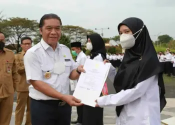 PJ Sekda Banten Al Muktabar, memberikan SK PPPK secara simbolis kepada guru SMA, SMK dan SKh di lapangan Setda KP3B, Senin (13/6/2022). (HERMAN SAPUTRA/SATELITNEWS.ID)