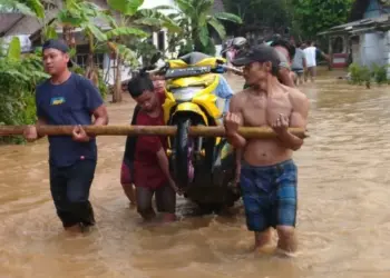 Warga mengangkat motor, korban banjir di Desa Pancaran, Kecamatan Munjul, Kabupaten Pandeglang, Sabtu (18/6/2022). (ISTIMEWA)