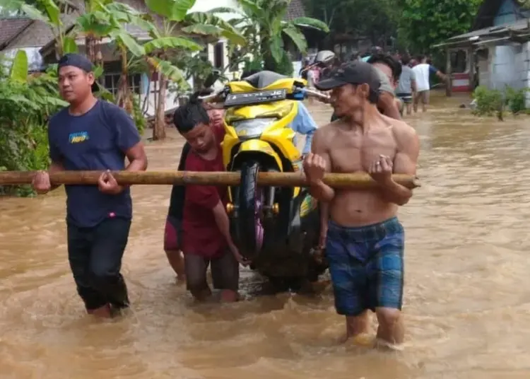 Warga mengangkat motor, korban banjir di Desa Pancaran, Kecamatan Munjul, Kabupaten Pandeglang, Sabtu (18/6/2022). (ISTIMEWA)