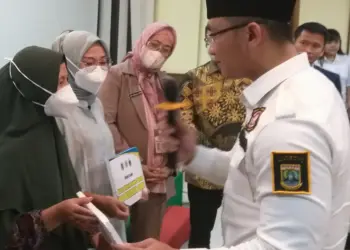 Secara simbolis, Ketua Karang Taruna Provinsi Banten Andika Hazrumy, didampingi Ketua Karang Taruna Pandeglang, dan Kepala Dinsos Pandeglang, menyerahkan BPJS Kesehatan gratis kepada penerima, di Aula salah satu rumah makan di Pandeglang, Selasa (28/6/2022). (ISTIMEWA)