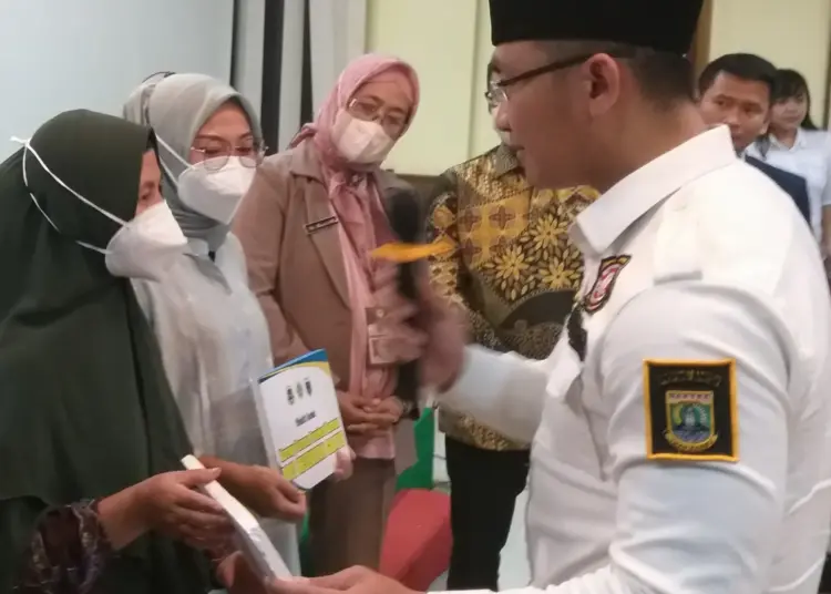 Secara simbolis, Ketua Karang Taruna Provinsi Banten Andika Hazrumy, didampingi Ketua Karang Taruna Pandeglang, dan Kepala Dinsos Pandeglang, menyerahkan BPJS Kesehatan gratis kepada penerima, di Aula salah satu rumah makan di Pandeglang, Selasa (28/6/2022). (ISTIMEWA)