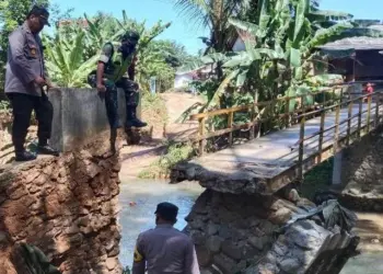 MONITORING–Jajaran Polsek Cimanggu dan aparatur Desa Rancapinang, monitor jembatan ambruk akibat diterjang banjir bandang, Selasa (28/6) lalu. Pihak Polsek-pun merekomendasikan beberapa hal, agar dilaksanakan oleh aparatur desa setempat, Rabu (29/6/2022). (ISTIMEWA)