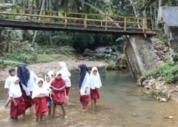 TEROBOS SUNGAI–Siswa SD di Kampung Cegog, sedang menerobos sungai, agar bisa sampai ke sekolah, Rabu (20/7/2022). (ISTIMEWA)