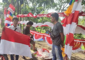 Para penjual bendera, di Jalan Raya Pandeglang-Labuan, tepatnya di Gardu Tanjak Kecamatan Pandeglang, sedang melayani pembeli, Minggu (14/8/2022). (NIPAL SUTIANA/SATELITNEWS.ID)