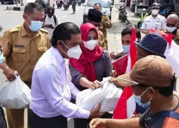 PJ Gubernur Banten, Al Muktabar, membagikan bingkisan bendera merah putih kepada para pelajar, di kawasan gedung Plaza Aspirasi KP3B, Curug, Kota Serang, Selasa (9/8/2022). (ISTIMEWA)