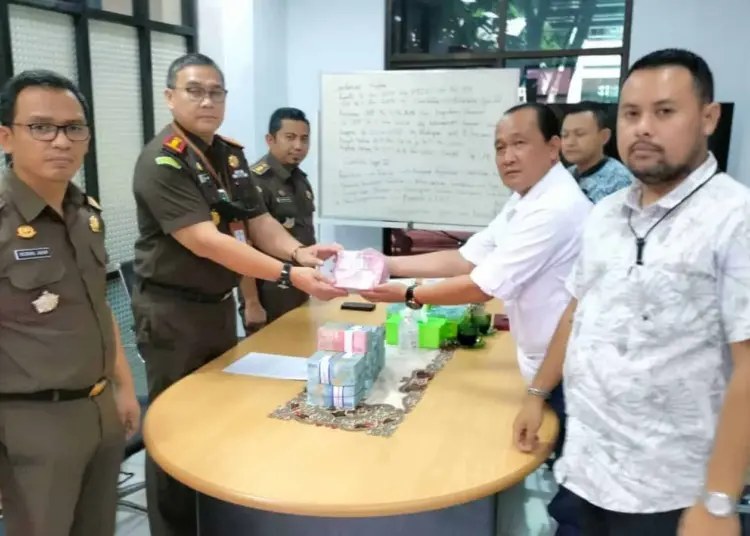 Kajari Serang Fredy D Simanjuntak, serahkan uang pengembalian kerugian negara ke Bank Mandiri Cabang Serang, Selasa (16/8/2022). Uang pengembalian itu, didapat dari kuasa hukum tersangka, Darussalam. (HERMAN SAPUTRA/SATELITNEWS.ID)