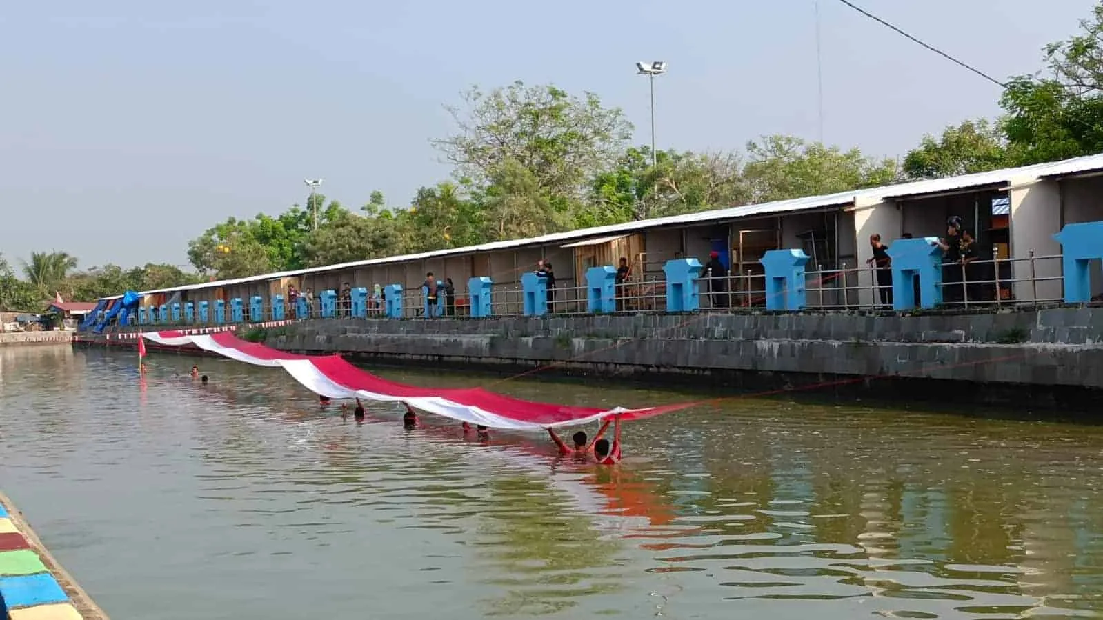 Warg Banten kibarkan bendera Merah Putih 50 meter, di kanal Surosowan, Rabu (17/8/2022). (LUTHFI/SATELITNEWS.ID)