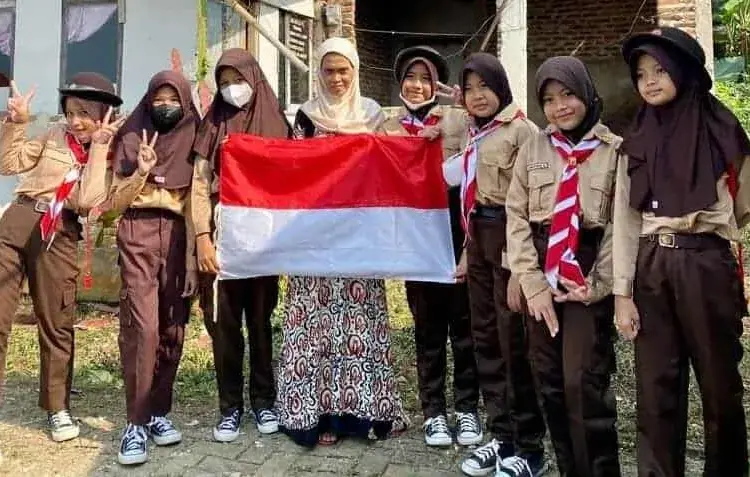 Pelajar SDN 4 Pandeglang, bagikan bendera merah - putih ke warga, guna semarakan HUT Kemerdekaan RI ke 77. (ISTIMEWA)