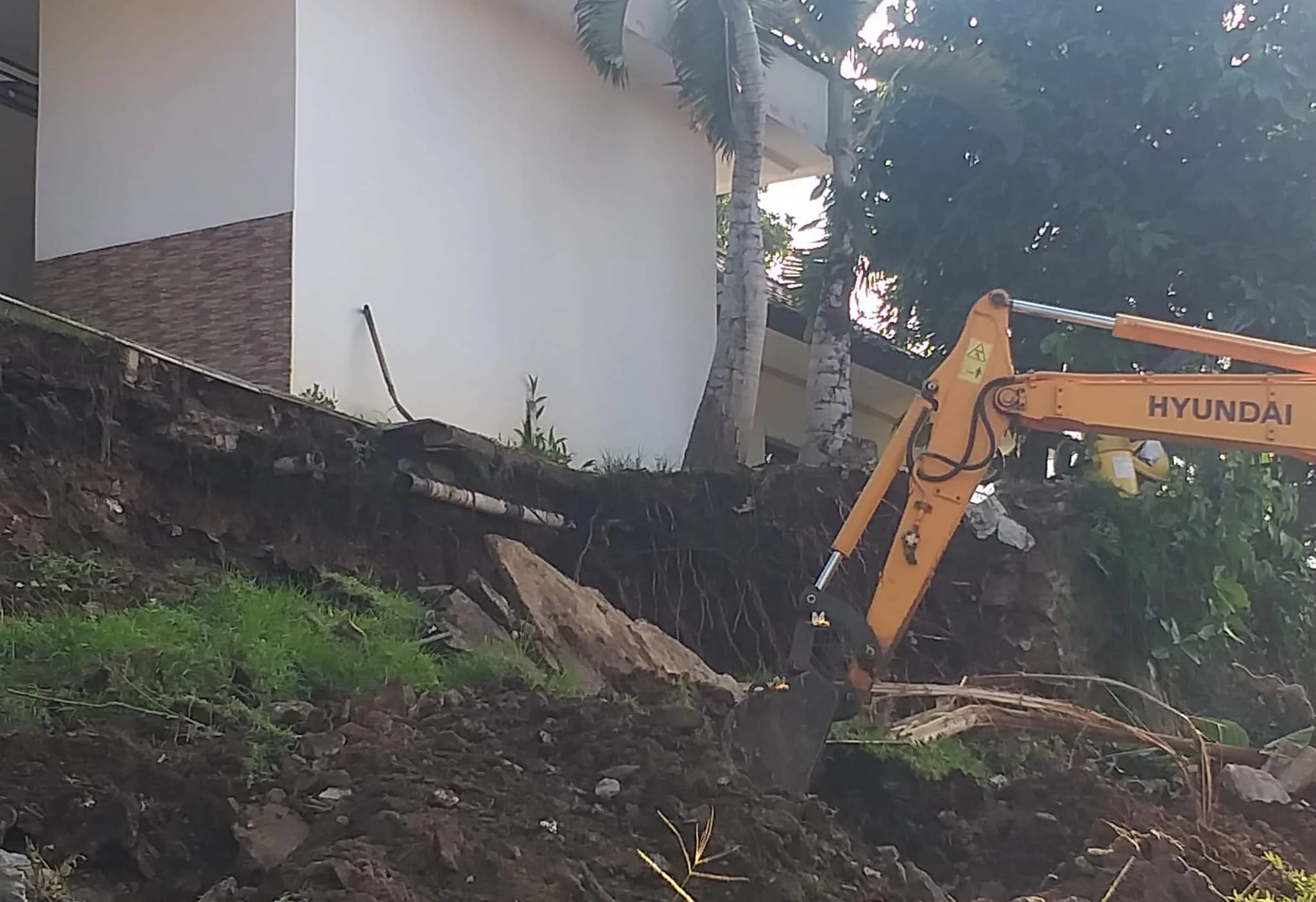 Material longsor di halaman belakang Pendopo Bupati Pandeglang, sedang dibereskan menggunakan alat berat, Senin (8/8/2022). (ISTIMEWA)