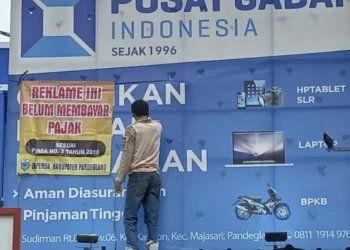 Petugas Bapenda Pandeglang, sedang melakukan penyegelan terhadap reklame yang belum membayar pajak, Rabu (16/11/2022). (ISTIMEWA)