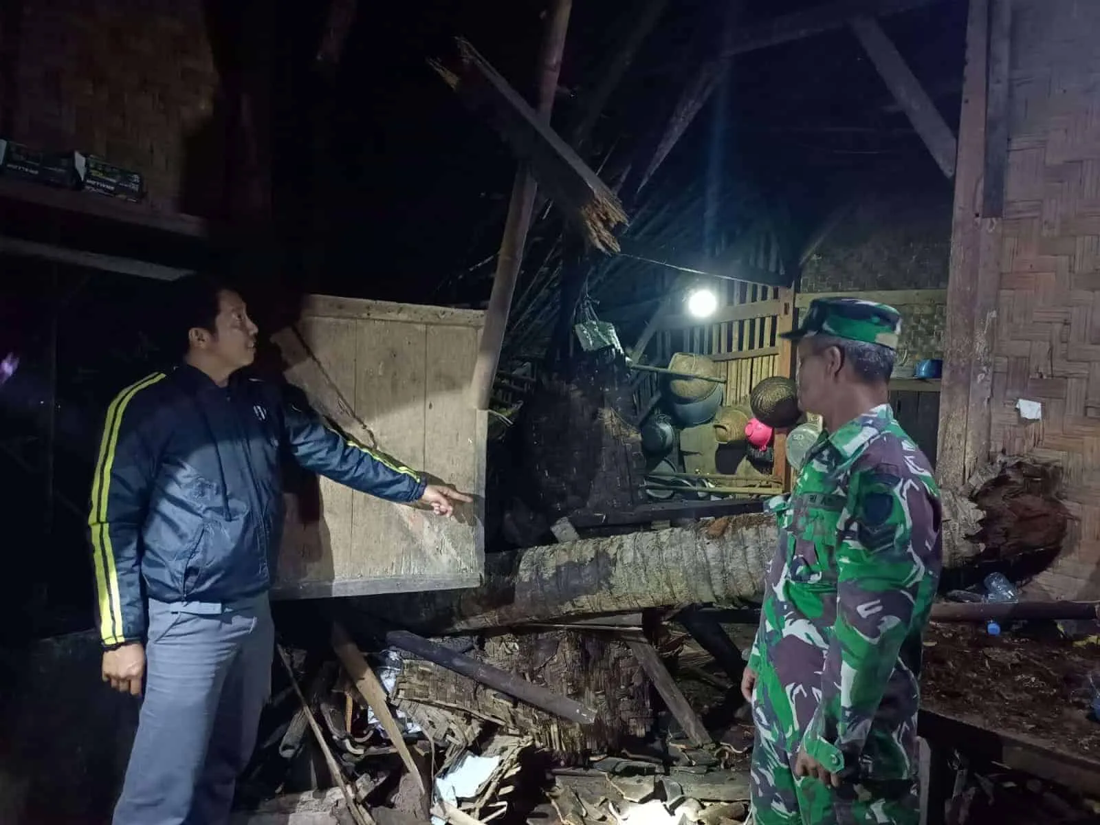 Para pihak sedang melakukan evakuasi pohon kelapa yang tumbang, menimpa rumah warga, Sabtu malam lalu. (ISTIMEWA)