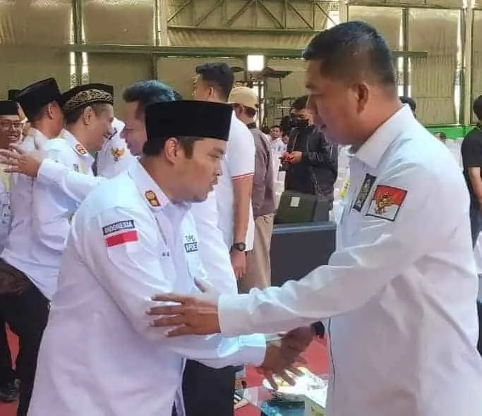 Fahmi Hakim (kanan), sedang berjabatan tangan dengan seorang Kepala Desa, di Kabupaten Serang. (SIDIK/SATELITNEWS.COM)