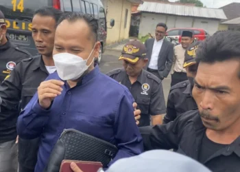 Oknum Anggota DPRD Pandeglang berinisial Y (bermasker), keluar dari Mapolres Pandeglang pasca diperiksa penyidik di Mapolres setempat, Selasa (20/12/2022). (NIPAL SUTIANA/SATELITNEWS.COM)