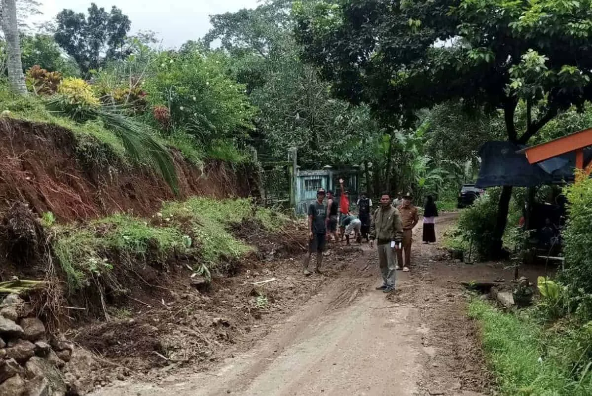 Warga membenahi tanah tebing yang longsor, di sepanjang ruas jalan Tegalwangi – Kubangkondang, Desa Tegalwangi, Kecamatan Menes, Kabupaten Pandeglang, Rabu (25/1/2023). (ISTIMEWA)