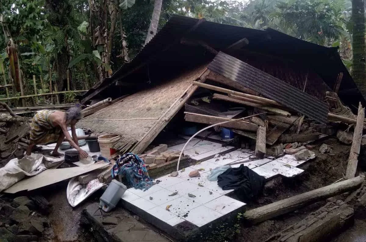 RUMAH ROBOH–Wanita paruh baya, sedang merapikan barang – barang berharga miliknya, pasca rumahnya roboh rata dengan tanah, Kamis (2/2/2023). (ISTIMEWA)