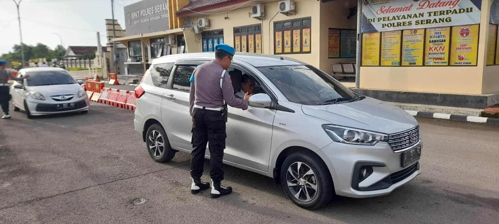 Seorang personel polisi sedang memeriksa kelengkapan dokumen pengendara, Senin (13/2/2023). (ISTIMEWA)