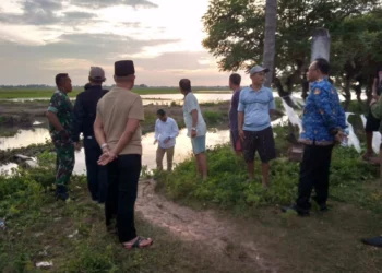 DATANGI LOKASI: Camat Pakuhaji Asmawi (batik biru) bersama Kades dan warga saat menyambangi lokasi anak tenggelam di danau bekas galian di Desa Kalibaru, Kecamatan Pakuhaji, Senin (20/2/2023). (ISTIMEWA)