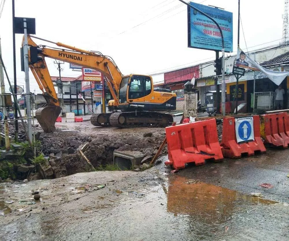 PERBAIKAN GORONG – GORONG–Ekskavator atau mesin pengeruk, diparkir di Jalan Raya Labuan – Pandeglang, tepatnya di perempatan Pasar Maja, Kecamatan Majasari, Kabupaten Pandeglang. Karena sedang ada proyek perbaikan saluran air di lokasi tersebut, Minggu (12/2/2023). (MARDIANA/SATELITNEWS.COM)