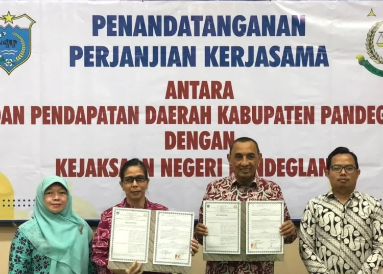 PENANDATANGANAN PKs–Kepala Bapenda Pandeglang Tatang Mukhtasar, menunjukkan perpanjangan Perjanjian Kerjasama (PKs) dengan Kejaksaan Negeri Pandeglang, di di Aula Kejaksaan Negeri Pandeglang, beberapa waktu lalu. (ISTIMEWA)