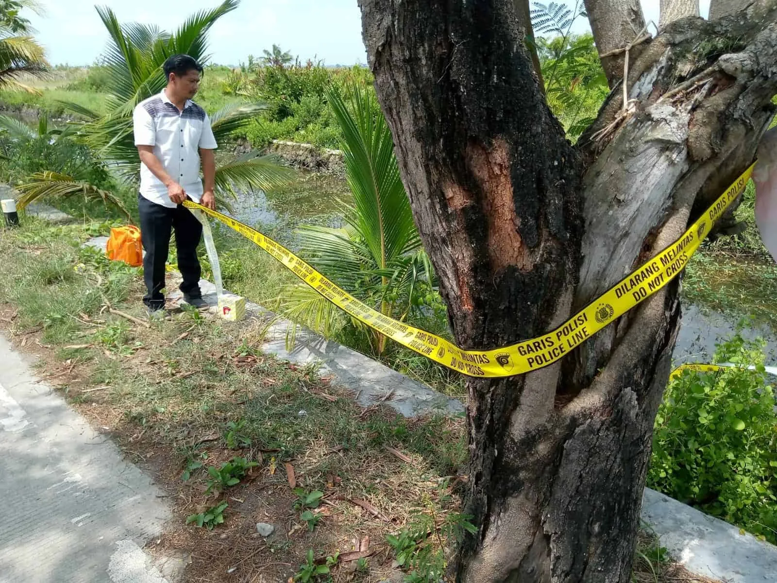 Personel polisi memasang garis polisi, di lokasi penemuan bayi di Pontang. (ISTIMEWA)