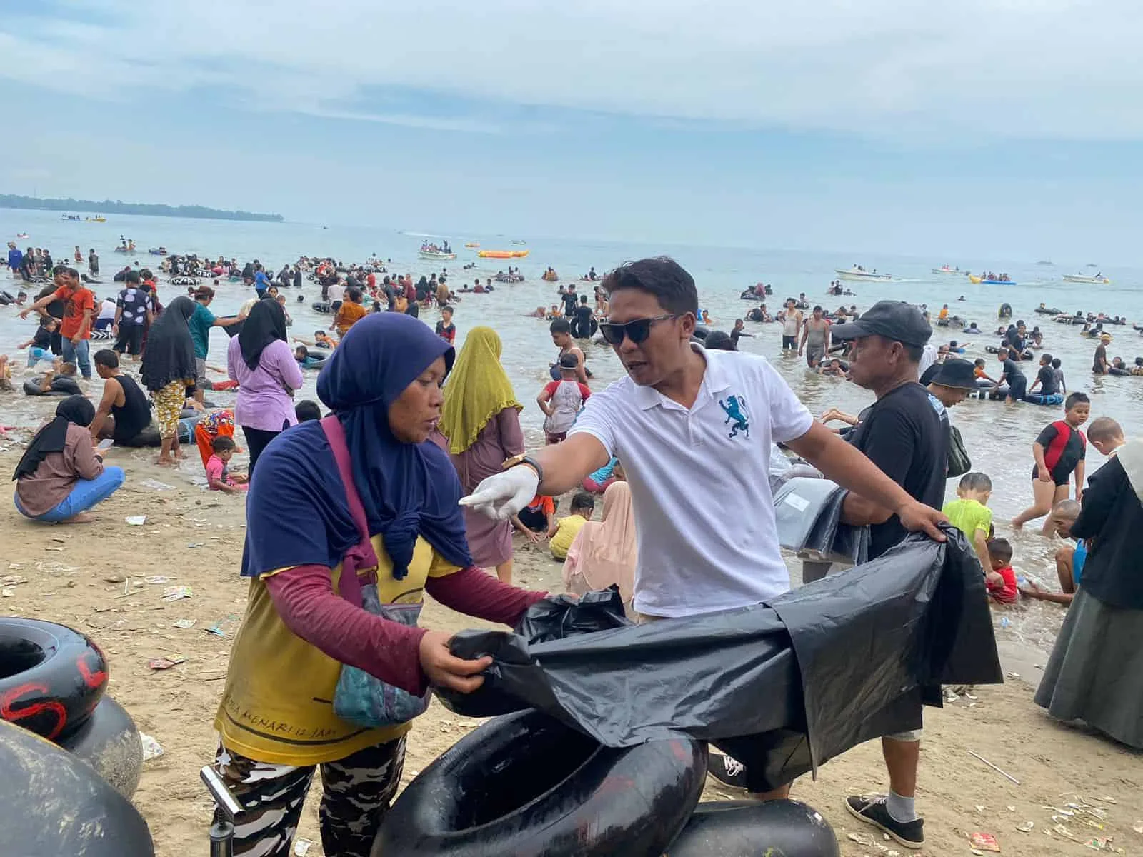 Koordinator KPPC, Franky Supriadi, membagikan plastik sampah kepada pedagang, untuk membantu membuang dan mengumpulkan sampah pada tempatnya, Minggu (30/4/2023). (ISTIMEWA)