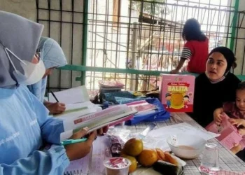 PEMERIKSAAN: Petugas puskemas sedang melakukan pemeriksaan terhadap balita. (ISTIMEWA)