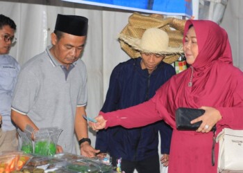 STAND PORWAN - Dirut Perumdam Tirta Berkah, Euis Yuningsih, membeli sejumlah makanan tradisional khas Pandeglang, di stand Porwan, Sabtu (1/4). (MARDIANA/SATELIT NEWS)