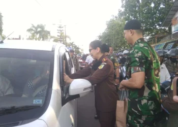 BERBAGI TAKJIL - Kepala Kejaksaan Negeri (Kajari) Pandeglang Helena Octavianne, duet bersama Komandan Kodim (Dandim) 0601 Pandeglang Letkol Inf Jani Setiadi, turun ke jalan membagikan 500 paket takjil kepada para pengendara di Jalan Ahmad Yani, Pandeglang, Rabu (5/4/2023). (ISTIMEWA)