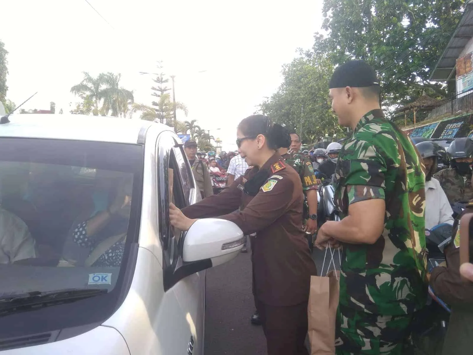 BERBAGI TAKJIL - Kepala Kejaksaan Negeri (Kajari) Pandeglang Helena Octavianne, duet bersama Komandan Kodim (Dandim) 0601 Pandeglang Letkol Inf Jani Setiadi, turun ke jalan membagikan 500 paket takjil kepada para pengendara di Jalan Ahmad Yani, Pandeglang, Rabu (5/4/2023). (ISTIMEWA)