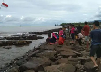 TEMUKAN MAYAT - Warga sedang melihat mayat, yang tergeletak di pinggir Pantai Caringin, Kecamatan Labuan, Pandeglang, Kamis (13/4/2023). (ISTIMEWA)