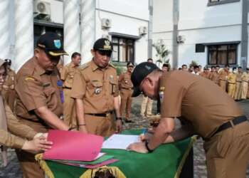 SERTIJAB - Plh Sekda Pandeglang, Asep Rahmat, sedang menandatangani berita acara sertijab, di halaman Setda Pandeglang, Senin (29/5). (ISTIMEWA)