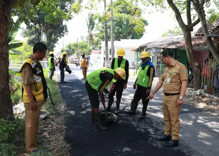 MENINJAU: Juhri selaku Kepala UPTD Jalan dan Jembatan Wilayah IV pada DBMSDA Kabupaten Tangerang, saat meninjau proses pemeliharaan jalan. (ISTIMEWA)