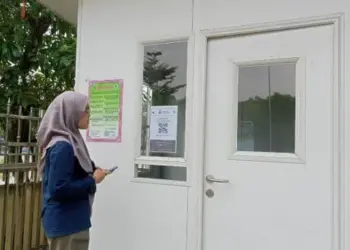 KANTOR: Situasi di depan kantor MUI Kabupaten Tangerang, Rabu (3/5). Terlihat salah satu pengunjung sedang melakukan scan barcode yang terpasang di depan kantor. (ALFIAN HERIANTO/SATELIT NEWS)