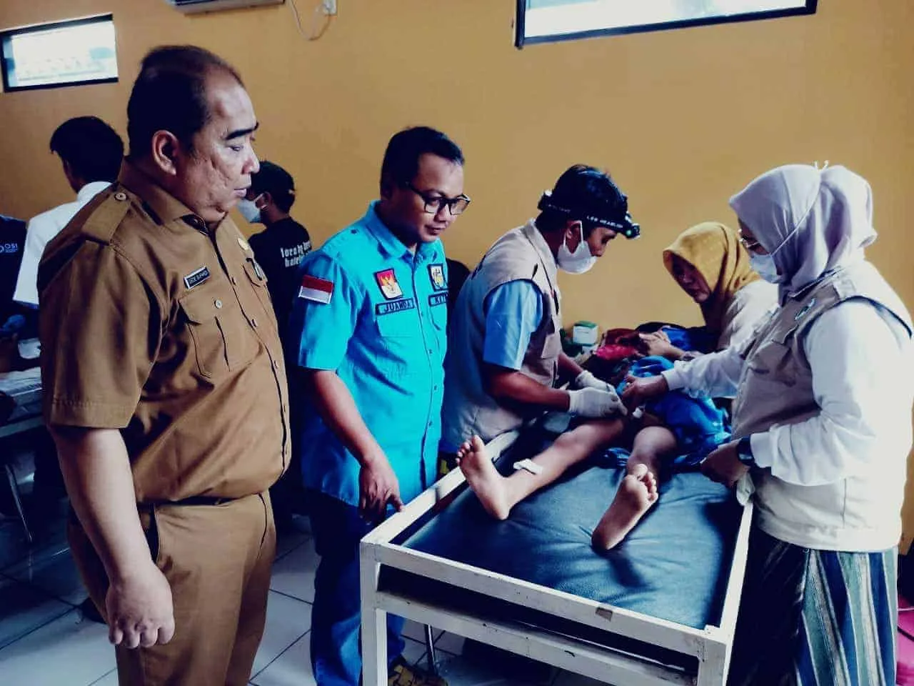 MENINJAU: Proses khitanan massal di Aula Desa Ranca Iyuh, Kecamatan Panongan, Senin (8/5). Terlihat ketua KNPI Kabupaten Tangerang sedang meninjau langsung salah satu anak yang terbaring di tempat tidur sedang dalam proses khitan. (ALFIAN HERIANTO)