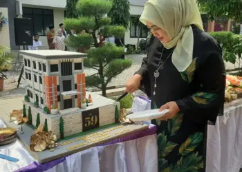 POTONG KUE: Direktur Utama RSUD Kabupaten Tangerang, Reniati terlihat sedang memotong kue ulang tahun yang berbentuk gedung RSUD Kabupaten Tangeranng, Rabu (17/5). (ALFIAN HERIANTO/SATELIT NEWS)