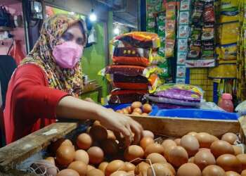 TELUR AYAM: Terlihat salah pengunjung Pasar Tradisional Tigaraksa sedang memilih telur ayam. (DOK/SATELIT NEWS)