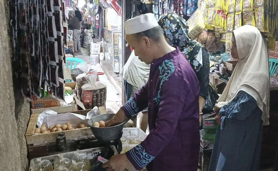 HARGA TELUR AYAM MELAMBUNG TINGGI–Pedagang telur ayam, di pasar tradisional Pandeglang, sedang melayani pembeli, Rabu (24/5/2023). (NIPAL SUTIANA/SATELITNEWS.COM)