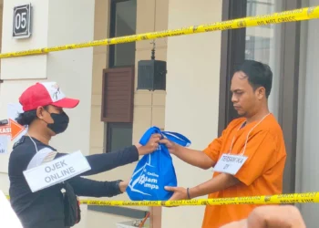 PENGIRIMAN PAKET: Suasana di Perumahan Lavon Swan City, Kecamatan Sindang Jaya. Terlihat seorang tersangka berinisial DY sedang melakukan adegan pengiriman paket berisi pil ekstasi melalui ojek online saat reka adegan, Senin (12/6). (ALFIAN HERIANTO)