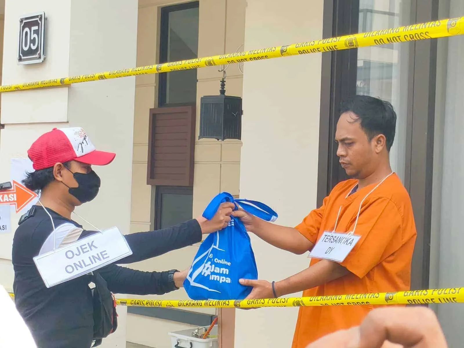 PENGIRIMAN PAKET: Suasana di Perumahan Lavon Swan City, Kecamatan Sindang Jaya. Terlihat seorang tersangka berinisial DY sedang melakukan adegan pengiriman paket berisi pil ekstasi melalui ojek online saat reka adegan, Senin (12/6). (ALFIAN HERIANTO)