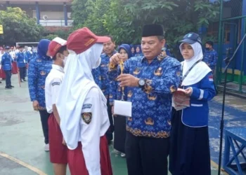 PENYERAHAN ID: Kepala Disdik Kota Tangerang Jamaluddin memakaikan kalung id kepada perwakilan siswa SMPN 16 Kota Tangerang dan SMPN 34 Kota Tangerang sebagai tanda dimulainya MPLS. MADE/SATELIT NEWS.COM