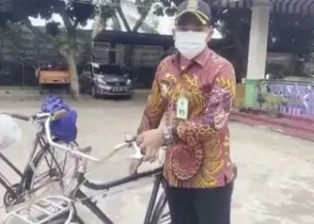 PAKAI SEPEDA:  Lurah Cisauk Kecamatan Cisauk Moch. Farly Gusriadi saat memakai sepeda untuk memberikan baju dan sembako untuk warga yang membutuhkan. (ISTIMEWA)