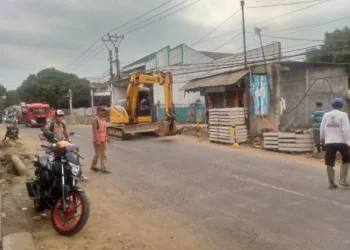 Sebuah alat berat digunakan untuk menggali tanah, yang akan dibuat drainase di Jalan Raya A. Yani. Tepatnya, di Kampung Masjid, Desa Labuan, Kecamatan Labuan, Kabupaten Pandeglang, Senin (7/8/2023). (FAHRIE/SATELITNEWS.COM)