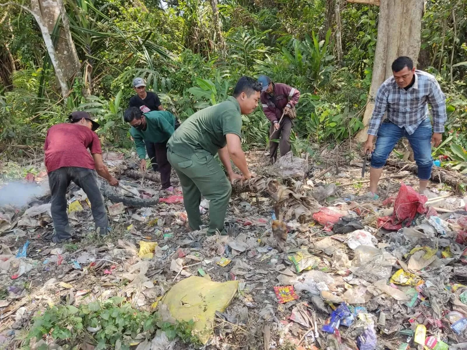 MEMBERSIHKAN SAMPAH : Petugas Balai TNUK dan pihak terkait, membersihkan sampah dan dedaunan kering, Selasa (3/10/2023). (ISTIMEWA)