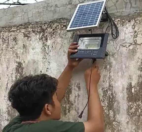 Peserta KKN, sedang memasang Lampu Penerangan Jalan Umum (PJU) dengan panel tenaga surya di Kecamatan Tanara. (ISTIMEWA)