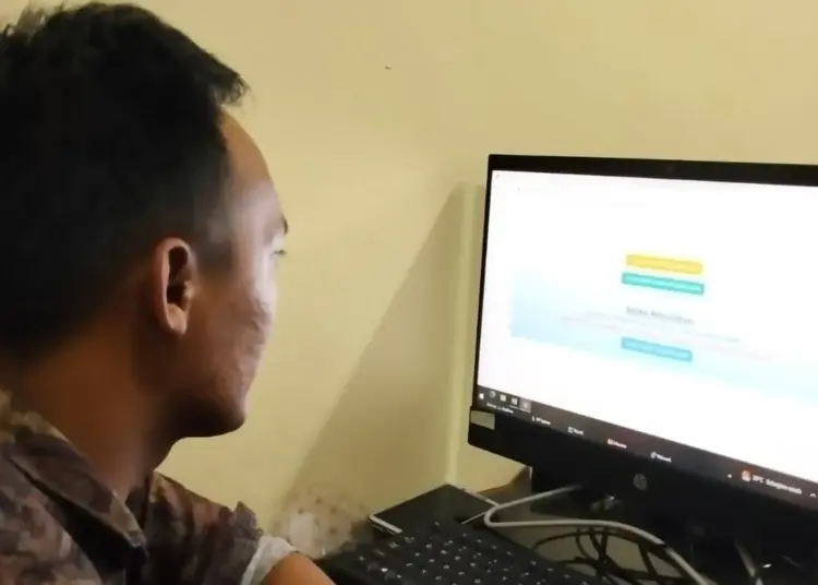 Seorang tenaga honorer di lingkungan Setwan Pandeglang, sedang melihat web penerimaan P3K. (ISTIMEWA)