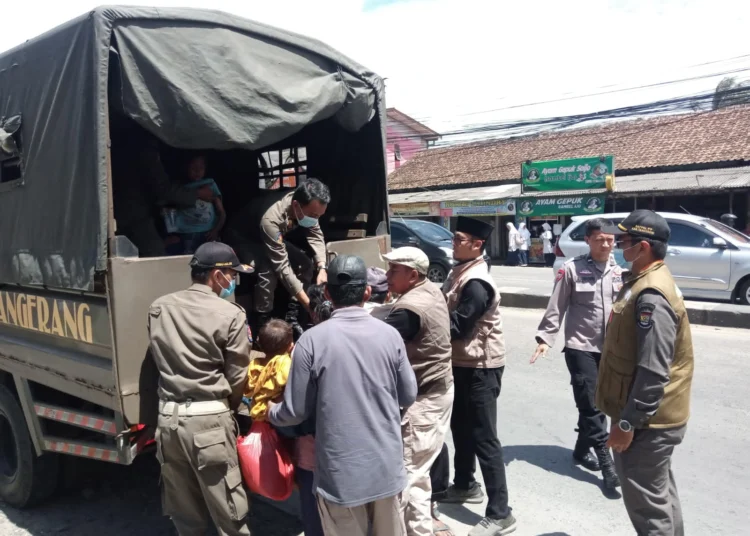 TERJARING RAZIA: Petugas Satpol PP dan Dinsos Kabupaten Tangerang bersama anggota Polresta Tangerang, sedang mengangkut salah satu PMKS ke mobil di Jalan Raya Serang, Desa Cikupa, Kecamatan Cikupa, Selasa (5/3). (ALFIAN HERIANTO)