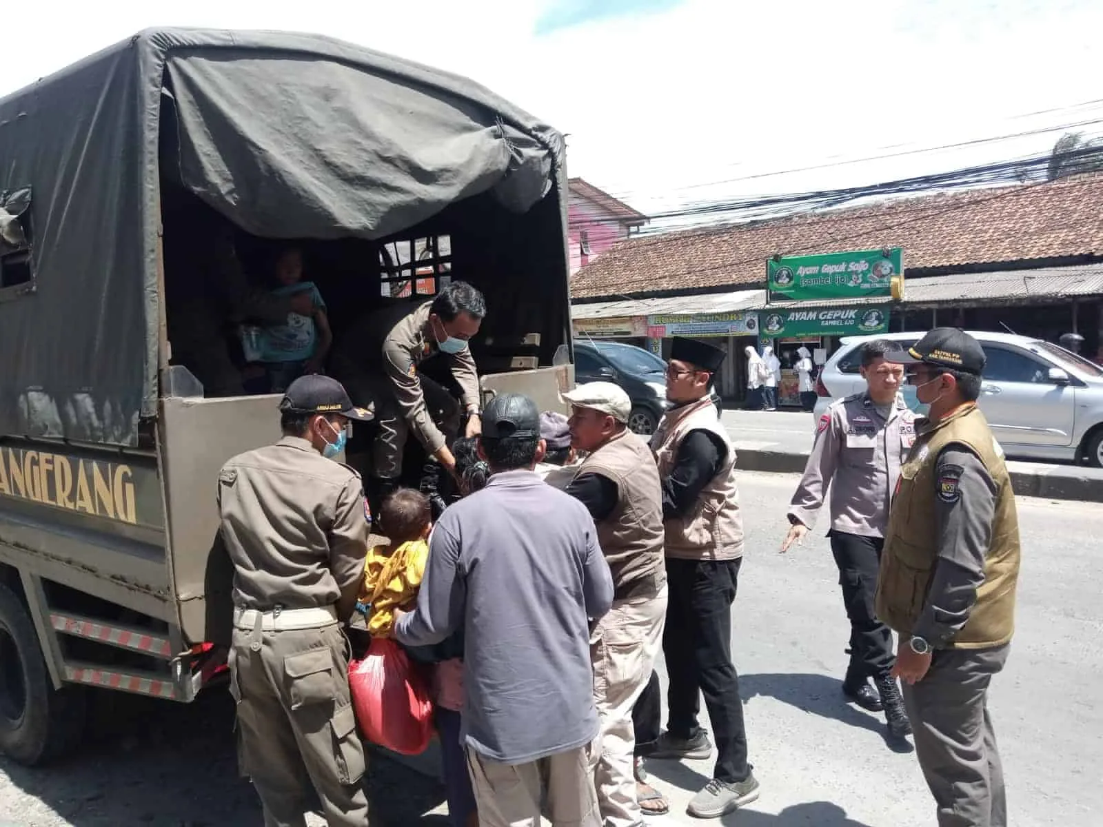 TERJARING RAZIA: Petugas Satpol PP dan Dinsos Kabupaten Tangerang bersama anggota Polresta Tangerang, sedang mengangkut salah satu PMKS ke mobil di Jalan Raya Serang, Desa Cikupa, Kecamatan Cikupa, Selasa (5/3). (ALFIAN HERIANTO)