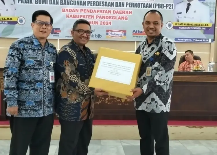 Ketua TAPD Kabupaten Pandeglang, Ali Fahmi Sumanta (tengah), menyerahkan buku tagihan pajak tahun 2024. (ADIB FAHRIE/SATELITNEWS.COM)