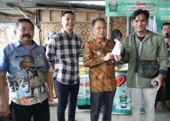 Pj Walikota Serang Yedi Rahmat, menyerahkan secara simbolis paket sembako subsidi kepada seorang warga di Cipocok Jaya, Kota Serang. (LUTHFI/SATELITNEWS.COM)